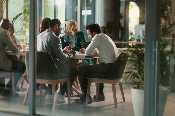 Collega's aan het overleggen in een vergaderruimte met laptop