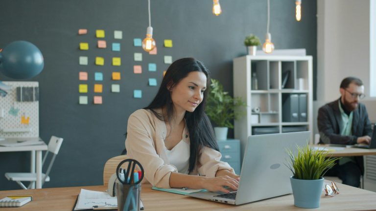 Woman working on laptop in modern office space